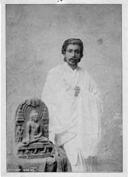 Young Anagarika Dharmapala beside a Buddhist statue